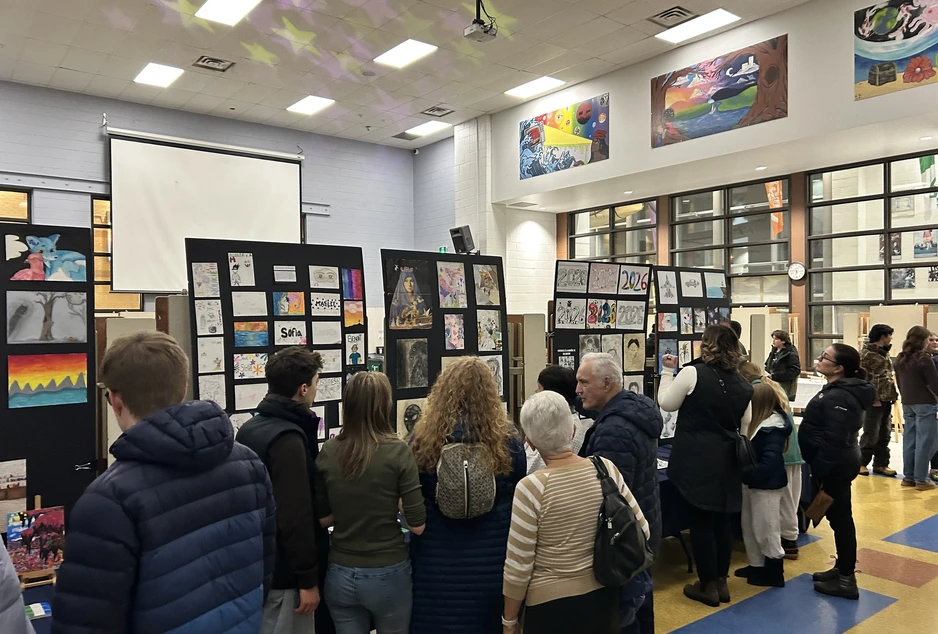 vernissage des élèves avec une foule qui regarde les oeuvres